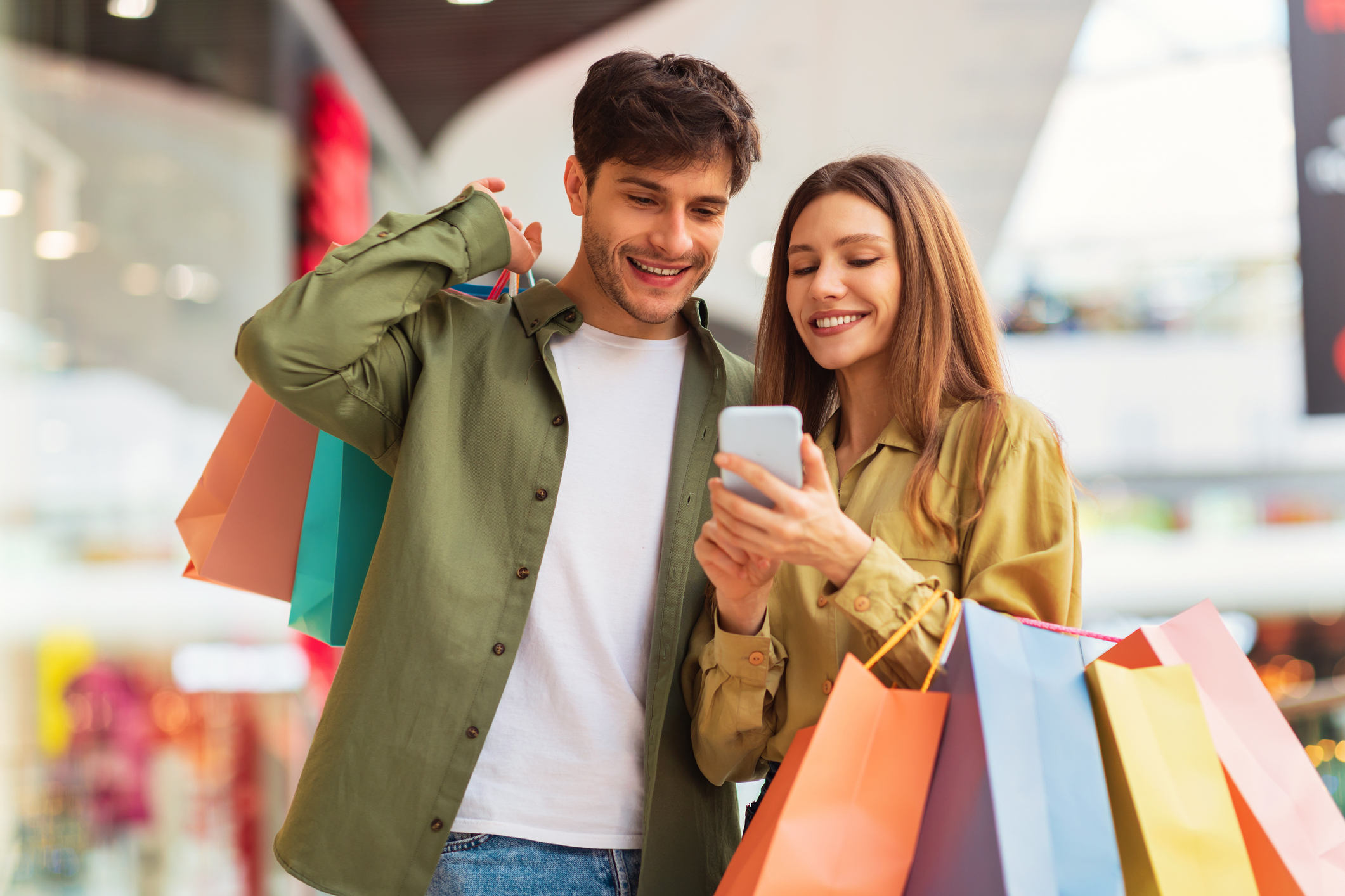 Young couple shopping and using smartphone – exploring loyalty program benefits