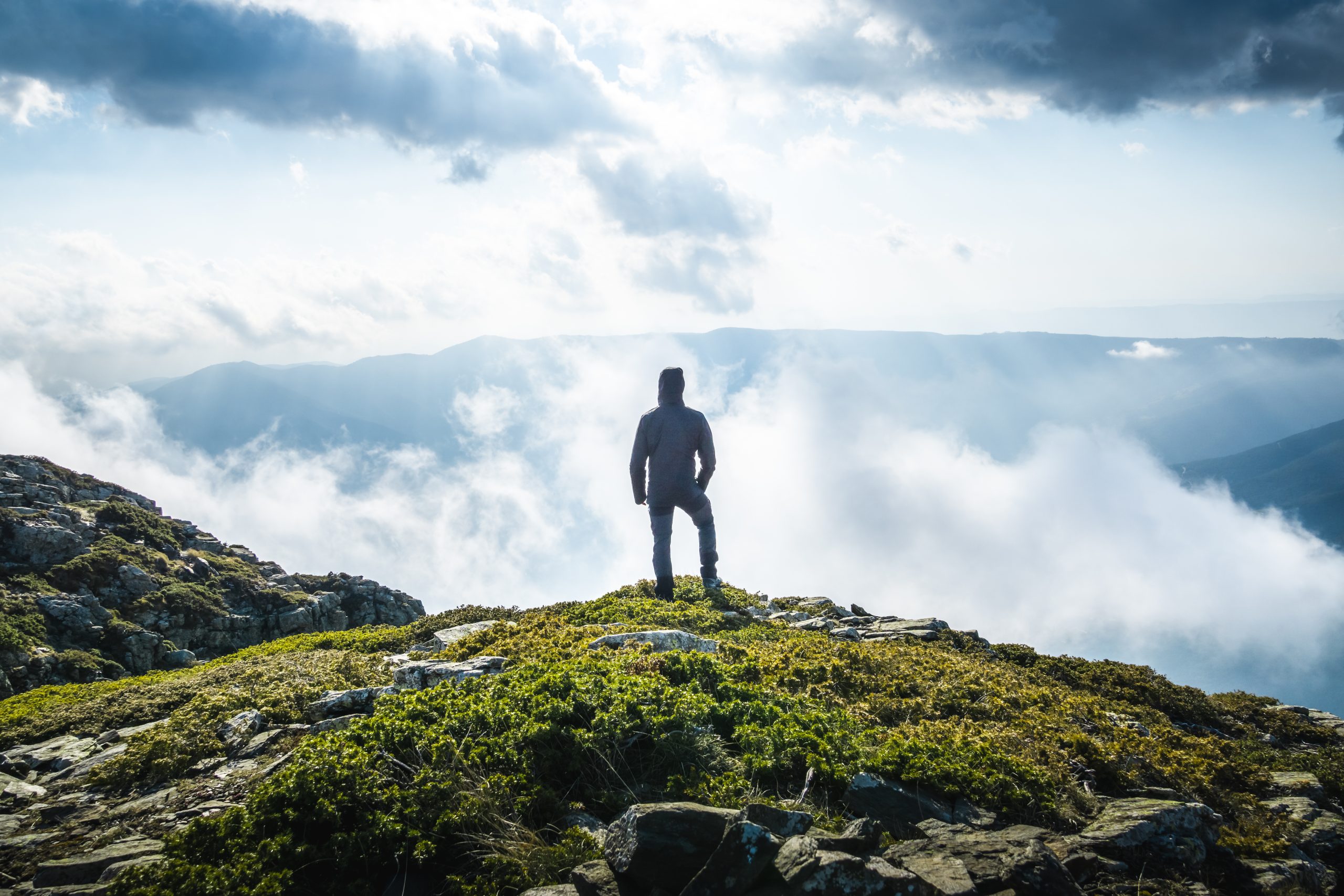Man standing on a mountain looking into the horizon